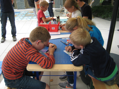 Erst schneiden, dann kleben, dann abtauchen lassen: Junge Besucher freuen sich über das Bastelangebot im Hof des BMBF. Foto: MARUM, Uni­ver­si­tät Bre­men 