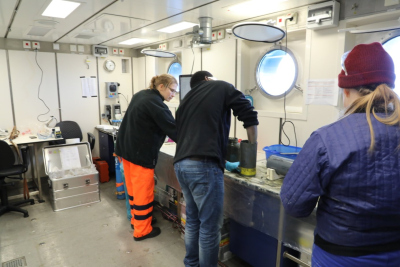 Annika Schnakenberg (l.), David Aromokeye and Sarah Coffinet bereiten einen Schwerelotkern für mikrobiologische Inkubationsexperimente vor (Foto: Natascha Riedinger)