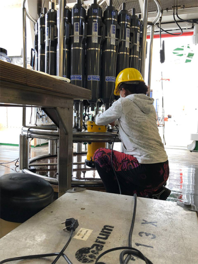 An der CTD-Rosette ist auch der Ultraschall-Doppler-Profil-Strömungsmesser (ADCP, gelbes Gerät) installiert. Alice überprüft das Gerät. Foto: MARUM/ Uni Bremen