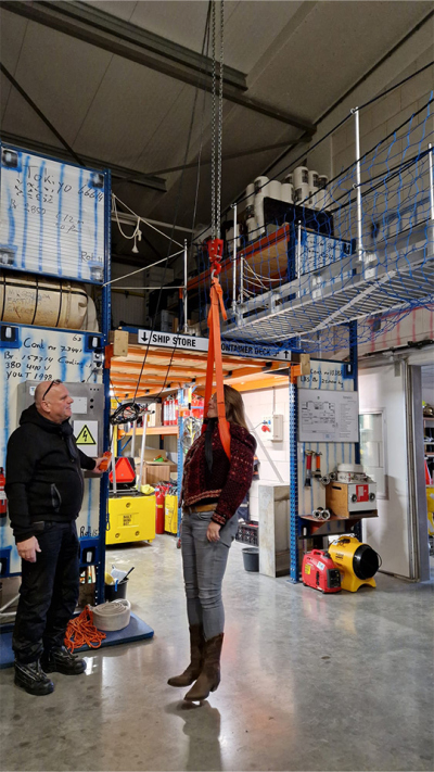 Training einer "Hubschrauberrettung". Man muss die Arme steif an der Seite halten, um nicht aus der orangefarbenen Schlinge zu rutschen. Foto: MARUM