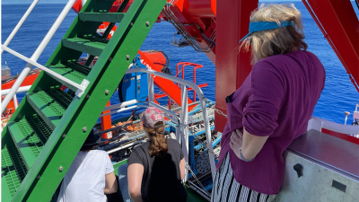 Das Einsetzen des MARUM-MeBo wird von Wissenschaftlerinnen an Deck beobachtet. Foto: MARUM, H. Pälike
