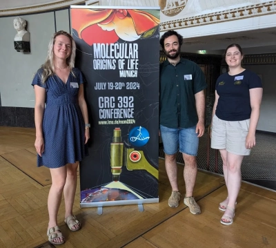 Joely with with Eric Runge and Lena Weimann next to the Conference poster