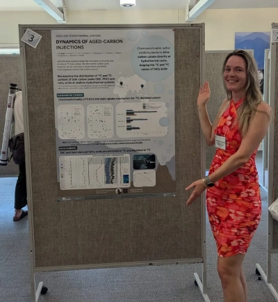 Joely next to her poster