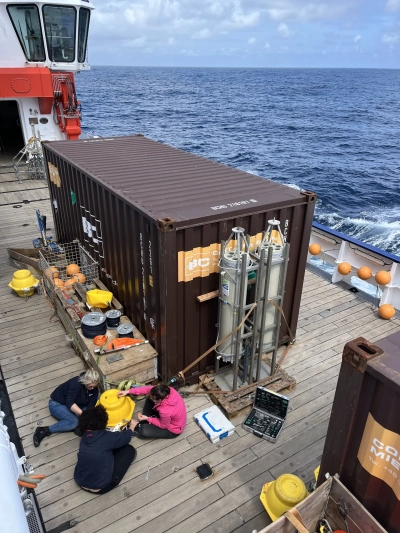 Abbildung zeigt Anja Seebeck, Julia Pamphile Dos Santos und Sofie Niggemeier bereiten sich auf den Einsatz der Driftfalle vor, mit der der Kohlenstoffexport im Ozean gemessen werden soll. Sie überprüfen, ob alle Bojen intakt sind.
