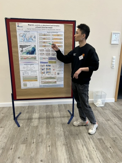 Pen Yang next to his poster