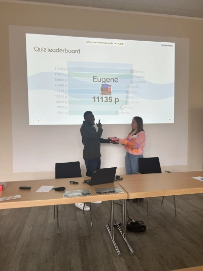 Anja handing over the prize to the winner of the quiz Eugene