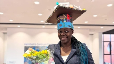 Nancy with her doctoral hat and flowers