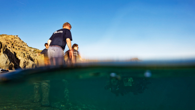 Der Test unter realen Bedingungen beginnt mit sogenannten Ballasttests. Das Team legt das SPIRULA-Fahrzeug ins seichte Wasser und justiert Lage und Auftrieb durch das Ein- bzw. Ausbauen von Gewichten. «Das Fahrzeug muss horizontal im Wasser liegen und soll einen leichten Auftrieb haben», erklärt Projektleiter Ralf Bachmayer (vorne). Foto: Werner Siemens-Stiftung; Oliver Lang Fotografie, Lenzburg