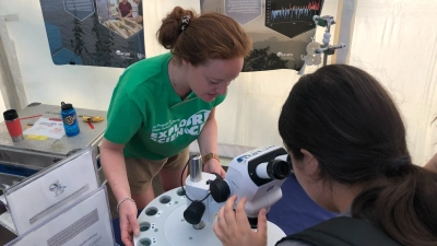 Ein Blick in das Klimaarchiv Ozeanboden: An einem Mikroskop können junge Besucher:innen Mikrofossilien anschauen. Foto: MARUM – Zentrum für Marine Umweltwissenschaften, Universität Bremen; U. Prange